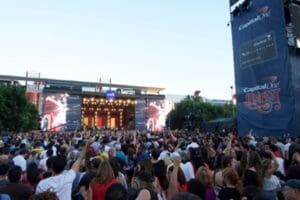 A crowd of people gathered in front of a stage at an outdoor event