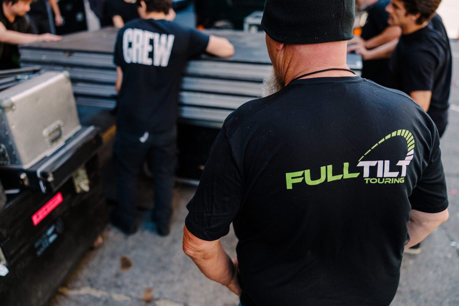 Full Tilt crew wearing branded uniforms actively managing live event logistics, highlighting a professional tour logistics company team.