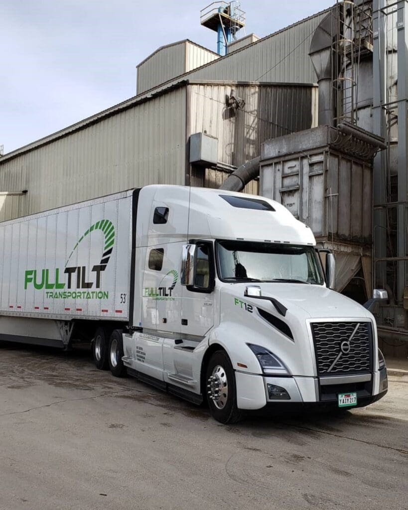 a Full Tilt Logistics Truck is parked in an industrial area